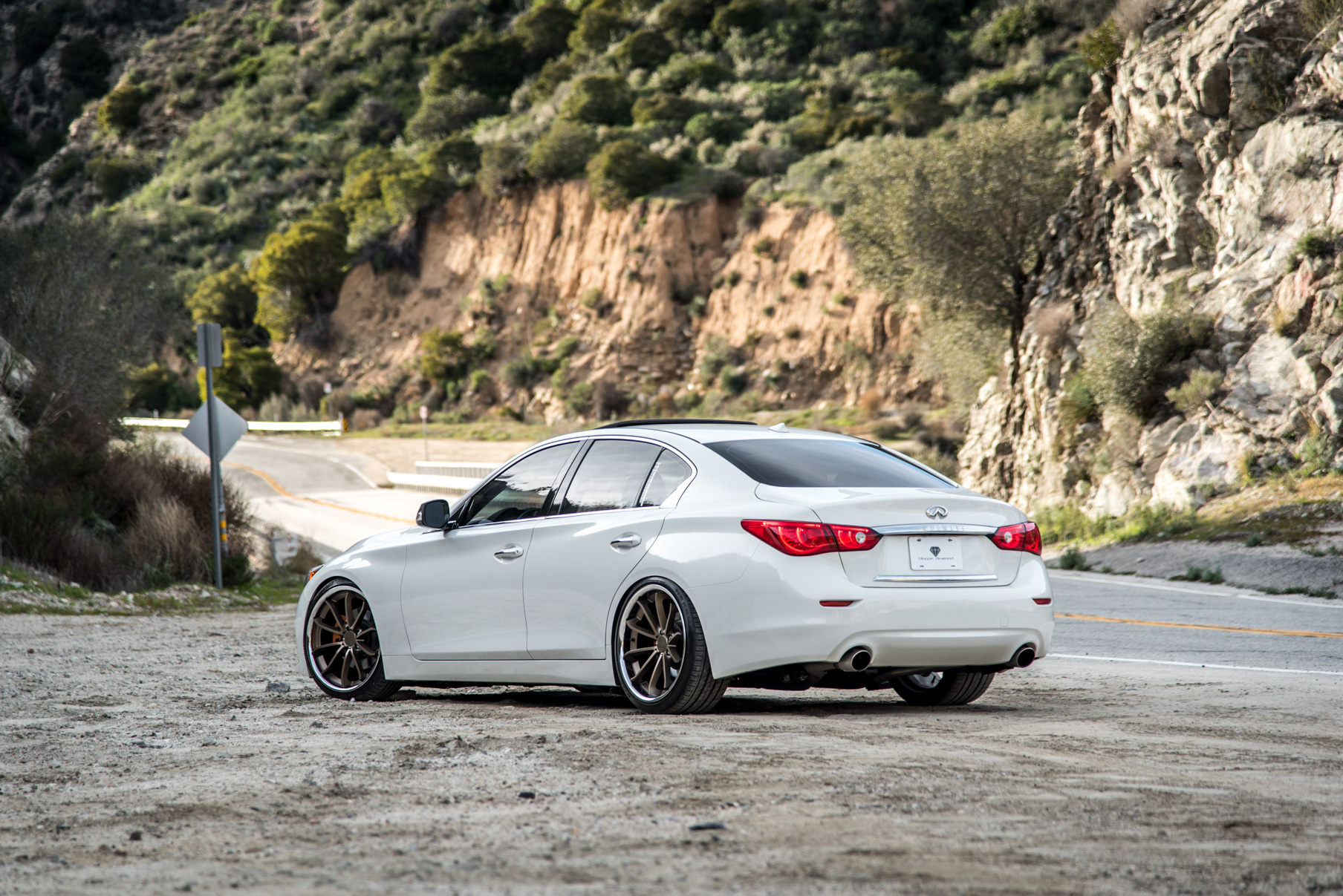 A White 2015 Infiniti Q50 on 20 Inch Blaque Diamond BD-23 Bronze Chrome Wheels