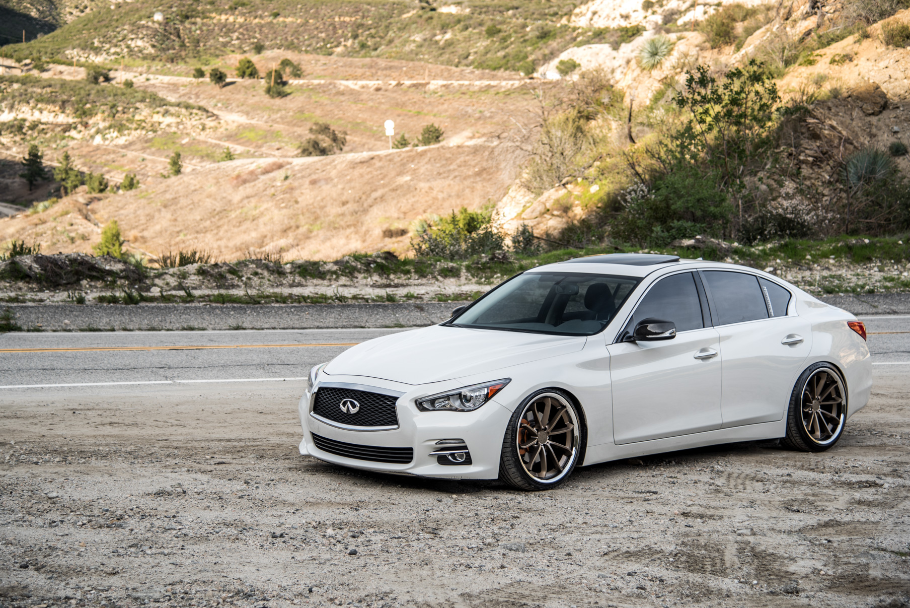 A White 2015 Infiniti Q50 on 20 Inch Blaque Diamond BD-23 Bronze Chrome Wheels