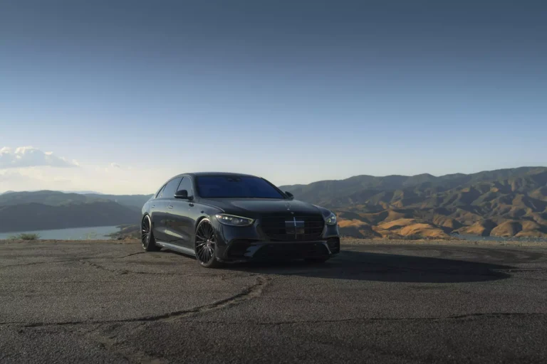 Front view of a 2024 Mercedes-Benz S-Class fitted with BD-715 Gloss Black Wheels parked against a scenic mountain backdrop.